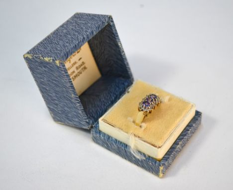 A three-stone tanzanite ring with small eight cut diamonds around, 9ct yellow and white gold setting, size M 1/2