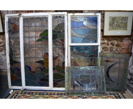 A metal-framed three-panel stained glass window, decorated with a river landscape with bridge, cottage, trees and bird, 124 x