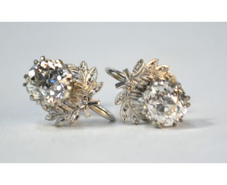 A pair of old cut diamond stud earrings in claw settings with leaf decoration, post stamped 9ct, possibly a conversion from a