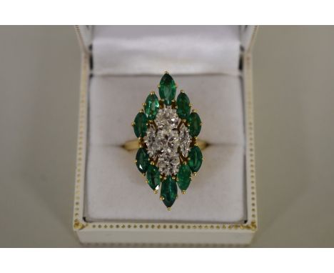 A diamond and marquis cut emerald cocktail ring, stamped .750, the three central brilliant cut diamonds totalling approximate