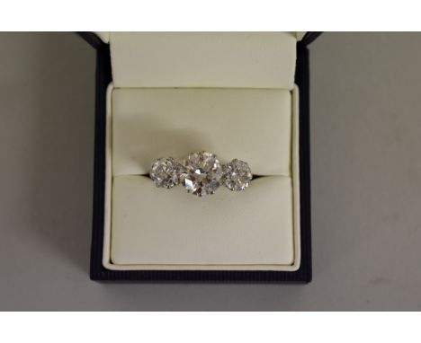 An old European cut diamond and platinum three stone ring,&nbsp;the central stone 2.6ct,&nbsp;colour J/K, clarity VS2/SI1 fla