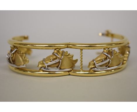 A gold openwork hinged bangle, decorated five horse heads, stamped 18k, 56.4g. 