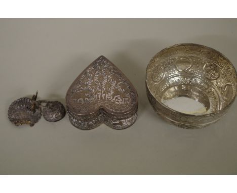 An Indian white metal heart shaped trinket box; together with an Arabic white metal bowl; and an Indian white metal peacock m