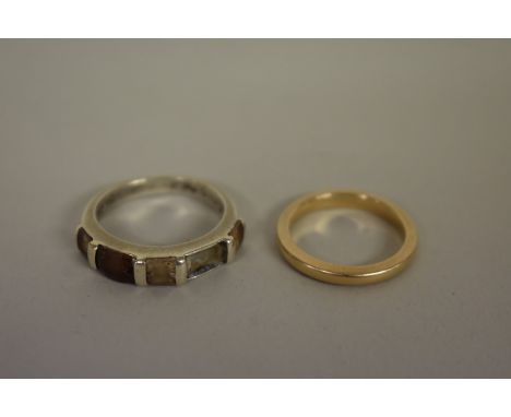 A wedding band, stamped 10k;&nbsp;together with a silver ring. 