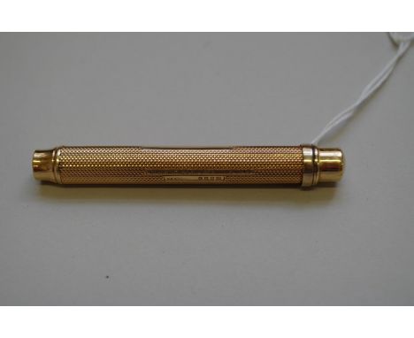 A gold engine turned propelling pencil,&nbsp;by Goldsmiths &amp; Silversmiths Co Ltd,&nbsp;stamped 18ct, 12.5cm, fully extend