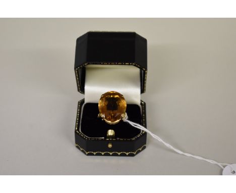 A large oval orange topaz dress ring, unmarked. 