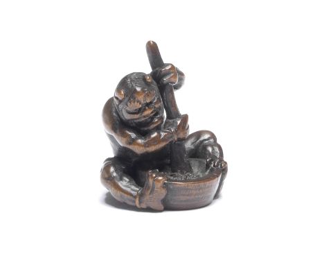 A WOOD NETSUKE OF AN ONI (DEMON) WITH A MORTAR AND PESTLEBy Ittan, Nagoya, Edo period (1615-1868), early/mid 19th centuryThe 