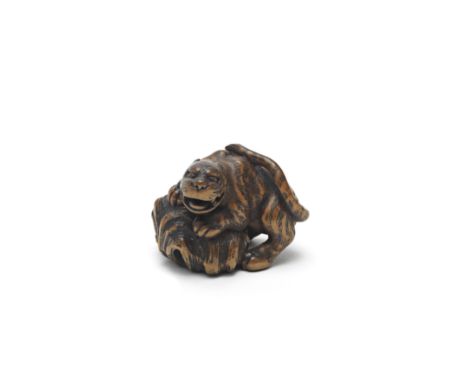 A WOOD NETSUKE OF A TIGER ON A ROCKBy Kokei, Kuwana, Ise Province, Edo period (1615-1868), early 19th centuryThe tiger steppi
