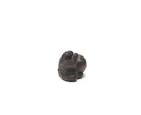 A WOOD NETSUKE OF A TANUKI (RACCOON DOG)By Ittan, Nagoya, Edo period (1615-1868), mid 19th centuryThe tanuki seated, beating 