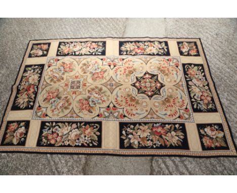 An Aubusson type rug with floral panel designs, 72" x 47" approx, and a circular tapestry cushion cover, 15 1/2" dia