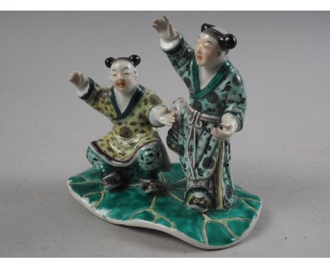 A Chinese porcelain famille verte enamel decorated figure group, 5 1/4" high (slight damages to fingers on one figure)Conditi