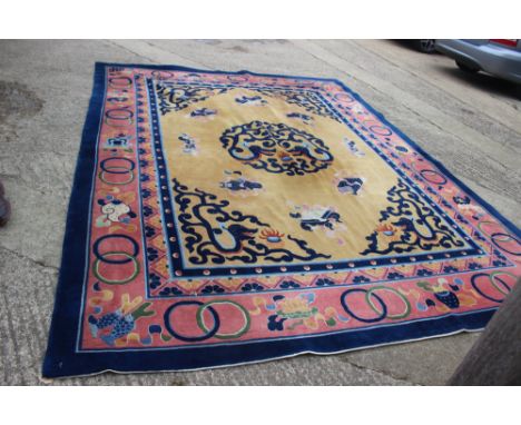 A Chinese contour pile carpet of traditional design with sacred objects on an old gold ground, 114" x 147" approx