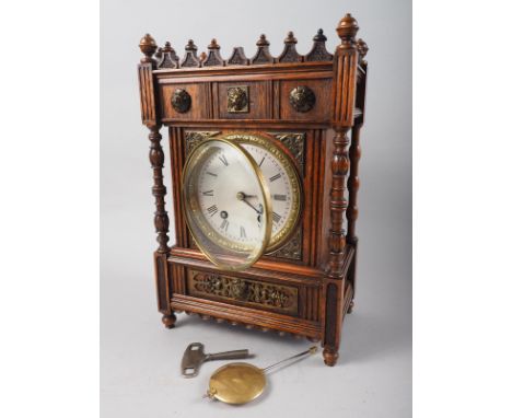 A late 19th century oak and brass mounted "Gothic" mantel clock with eight-day striking movement and silvered dial, 13 3/4" h