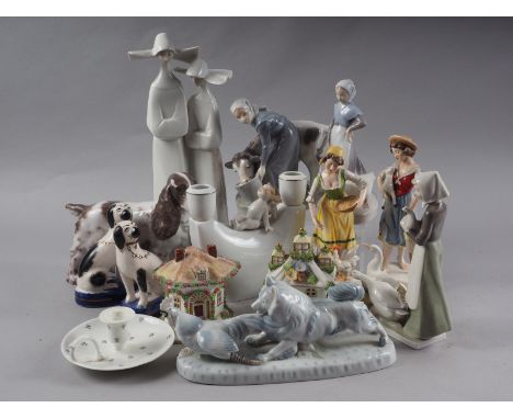 A Royal Copenhagen model of a spaniel, 6 1/4" high, another Royal Copenhagen figure of a woman feeding a calf, 6 1/4" high, a