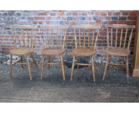 A set of four circular panel seat and stick back kitchen chairs, on turned and stretchered supports 