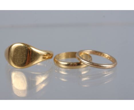 An 18ct gold signet ring, size U, 7.3g, an 18ct gold wedding band, size K, 2.1g, and a yellow metal wedding band, stamped 14k