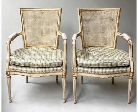 FAUTEUILS, a pair, Louis XVI style, parchment parcel gilt, with cane panelled back and button seats (cane restored), 62cm W. 