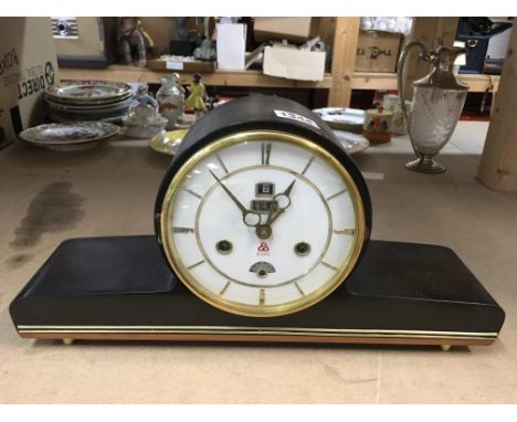 A simulated mahogany mantle clock. 15 day with date aperture