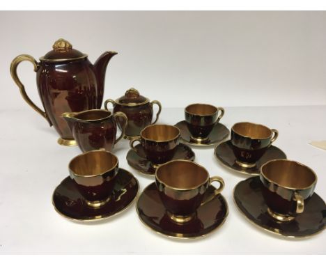 A Carlton Ware Rouge and gilt ceramic coffee service complete six place setting and with no obvious damage.