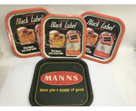 Three vintage pub trays advertising “Black label larger” and one for “Mann’s”