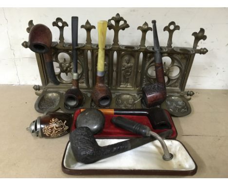 A brass pipe rack with various pipes