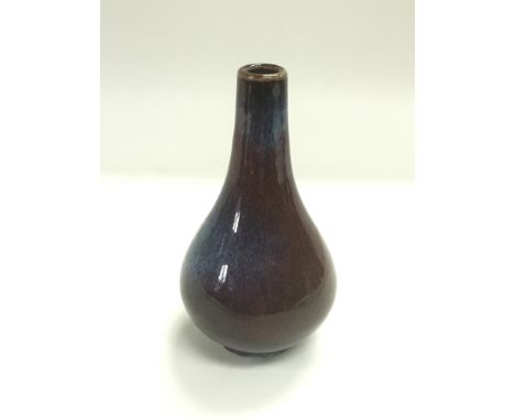 A small ceramic bottle vase with a purple and blue glaze, approx height 13cm.