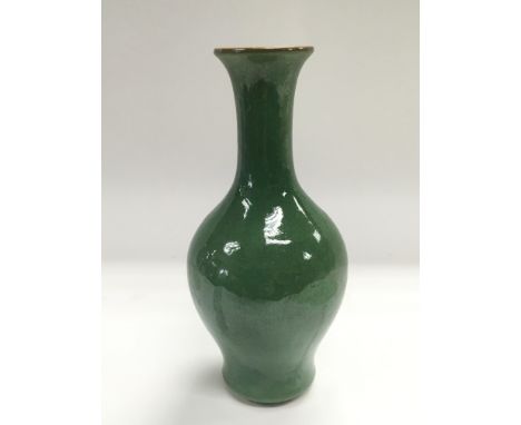 A green ceramic vase with an elongated neck and a white interior, approx height 21cm.