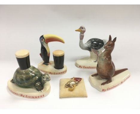 Four Carltonware Guiness advertising figures and a Guiness toucan brooch (5).