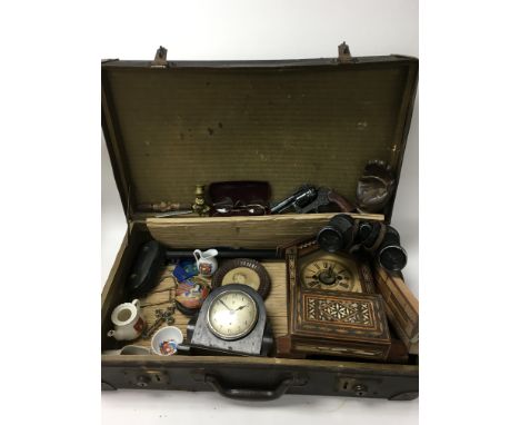 A vintage suitcase coin training an assortment of oddments and interesting paraphernalia. These include vintage spectacles, t