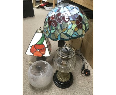 An oil lamp with a clear glass reservoir plus two Tiffany style table lamps (3).