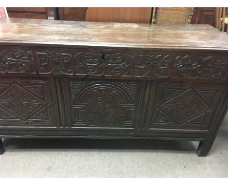 An oak blanket chest the hinged lid above a carved panel front, approx 145 cm by 55 cm height with a carved date of 1766