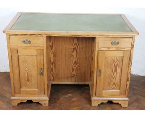 A late Victorian pitch pine library desk, with two short drawers and two cupboard doors, the other side with two large panell