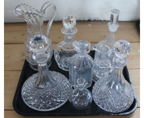 Three trays containing a collection of glass ware, to include; ships decanters and stoppers, jugs, globe and shaft decanters 