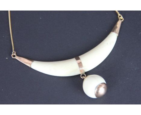 An ivory bead and gold set necklace, Egyptian circa. 1910, designed as a crescent shaped ivory panel suspending a carved ivor