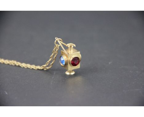 A 9ct yellow gold lantern pendant set with multi coloured paste stones, suspended from a fine decorative rope twist chain, to