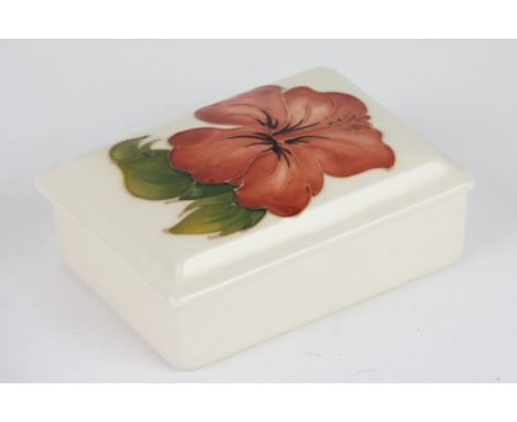 A Moorcroft Pink Hibiscus rectangular trinket box, impressed marks, 13cm long along with a circular dish 11.5cm diameter in t