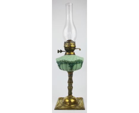 A Victorian brass oil lamp, with moulded opaque green glass reservoir, on a domed square base, glass chimney, 40cm