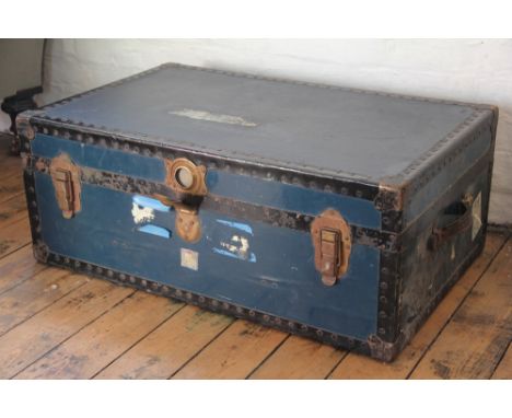 A vintage metal bound travelling trunk, with brass clasps and leather handles 32cm x 81cm x 51cm