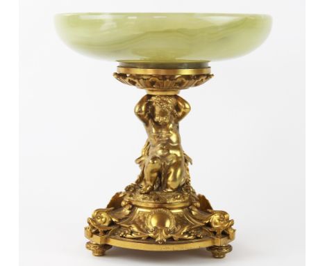 A gilt metal and onyx mounted centre piece, 20th century, designed as a kneeling putto supporting a shallow onyx dish, raised