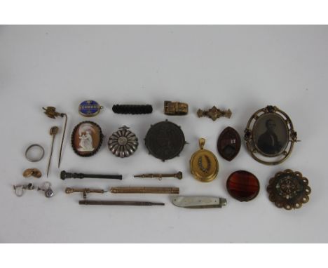 A collection of jewellery, to include; a coral and seed pearl set locket, a buckle form scarf slide, a large Victorian brooch