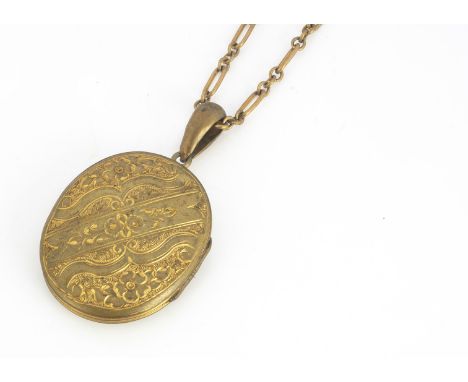An early 20th century oval engraved locket, with engraved leaf and floral design, on a gilt metal oval linked chain, 42 cm to