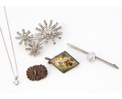 A garnet oval gilt metal brooch, together with a moonstone white metal bar brooch, A Persian bone and white metal hunting bro