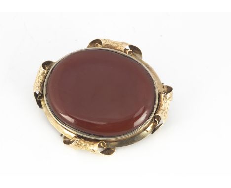 A Victorian yellow metal and red hardstone mourning brooch, 55mm wide, the oval frame supporting a burgundy coloured stone wi