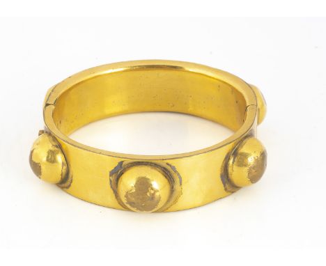 A 19th century gilt metal hinged bangle, oval shape with applied roundels, 5.5 cm by 5.2 cm
