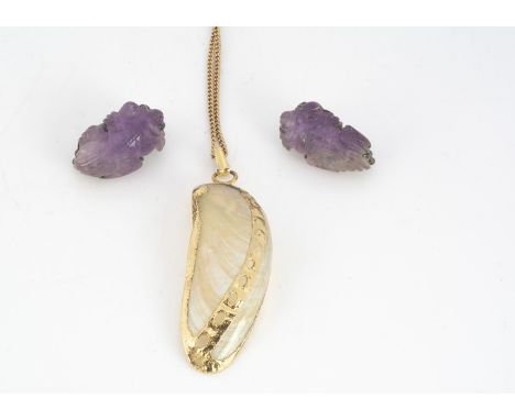 A shell and yellow gold pendant and chain, the shell with pierced decoration heightened in yellow metal, on a curb linked cha