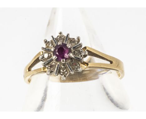 An 18ct marked ruby and diamond cluster ring, centred with a ruby surrounded with eight cut diamonds, all in white metal, rin
