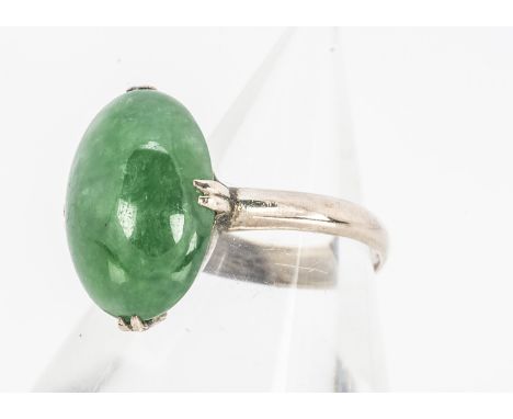 A Chinese jadeite jade cabochon and yellow metal ring,  the stone in four claw setting marked 18k, ring size O, jade 7.9cts, 