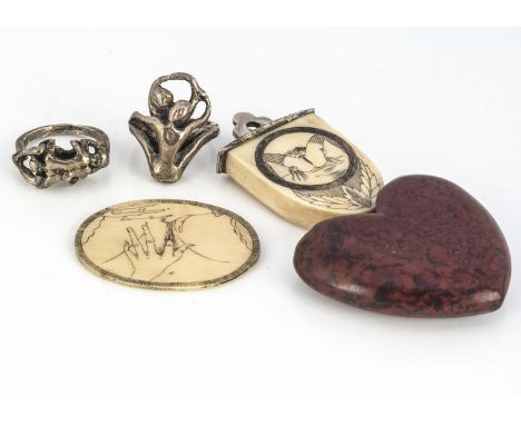 Four erotic jewels, including two white metal rings of lovers paying each other intimate attention, ring size K&amp;H, and tw