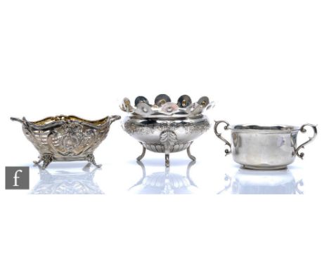 A hallmarked silver twin handled bowl raised on four scroll feet, with a similar sugar basin, total weight 8.5oz, with a simi