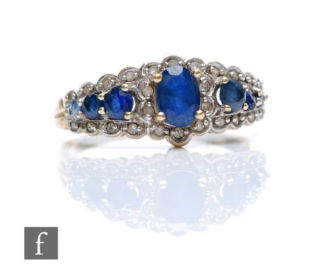 A 9ct hallmarked Edwardian style sapphire and diamond ring, seven sapphires within a border of diamonds, weight 2.8g, ring si